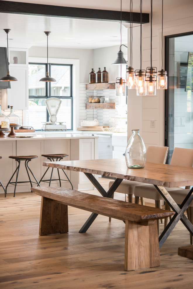 Ispirazione per una sala da pranzo aperta verso la cucina country con pareti bianche, parquet chiaro e pavimento beige