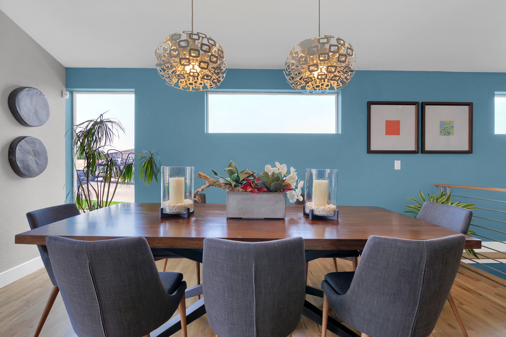 Пример оригинального дизайна: большая гостиная-столовая в современном стиле с синими стенами и светлым паркетным полом