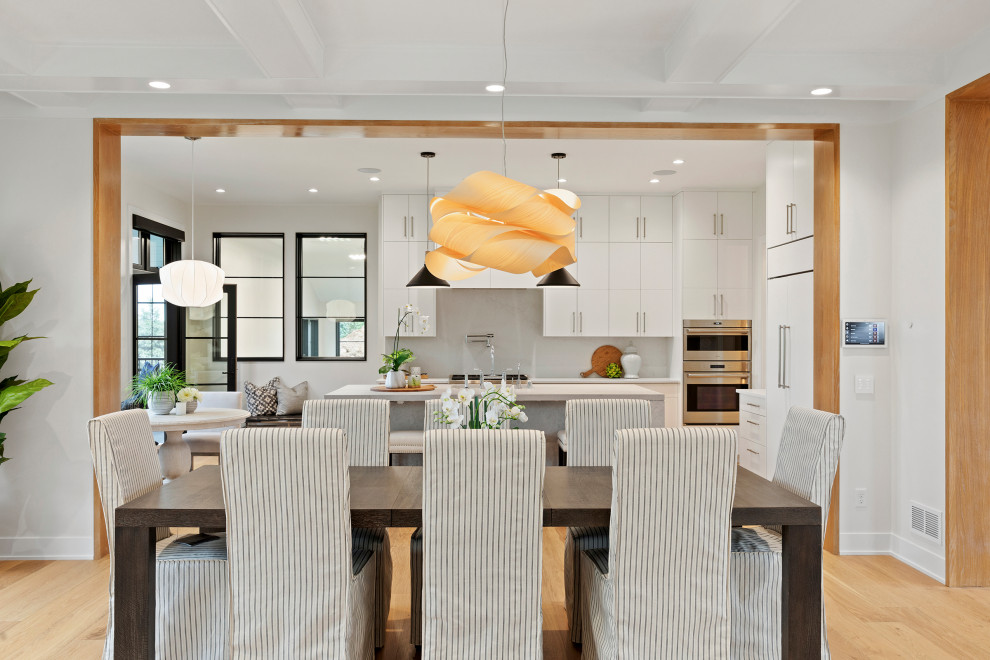 Idee per una grande sala da pranzo aperta verso il soggiorno design con pareti bianche, pavimento in legno massello medio e pavimento marrone