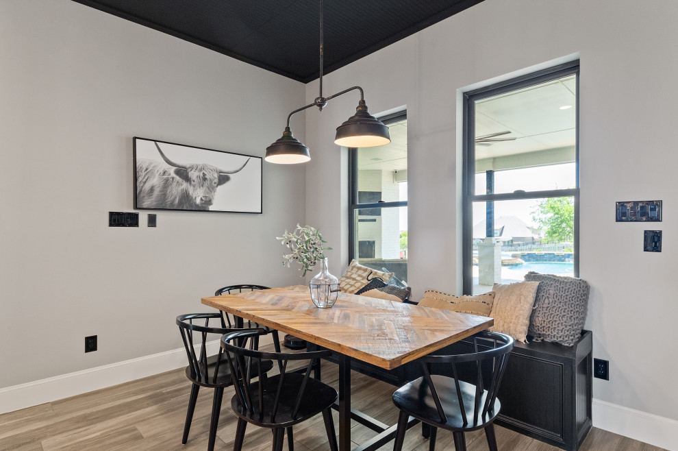 Cette photo montre une salle à manger ouverte sur la cuisine nature de taille moyenne avec un mur gris, un sol en bois brun, un sol marron et un plafond en lambris de bois.