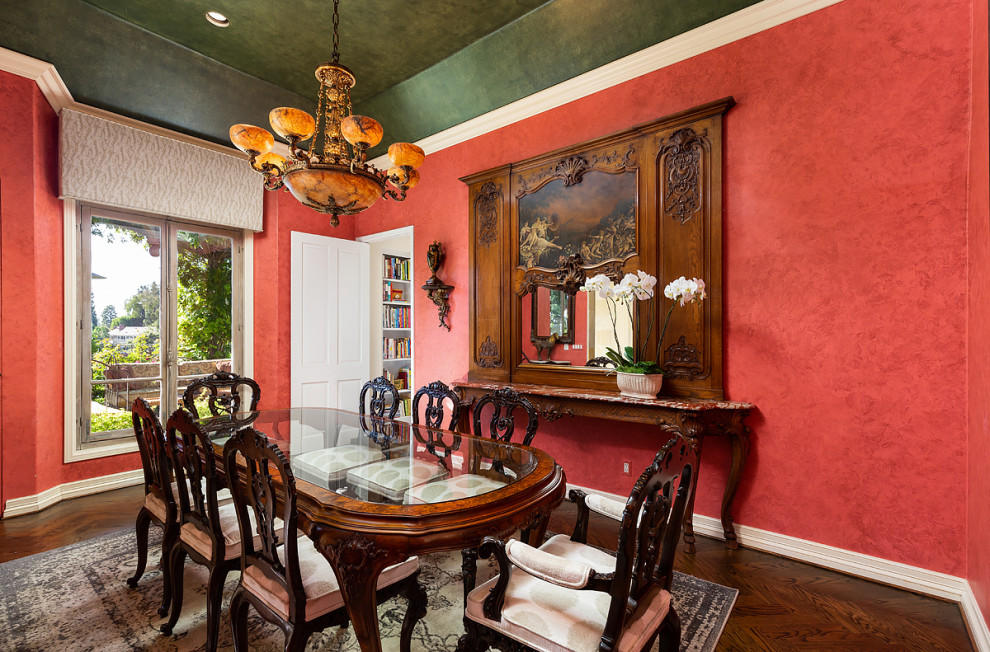 Immagine di una grande sala da pranzo rustica chiusa con pareti rosse, parquet scuro e pavimento marrone