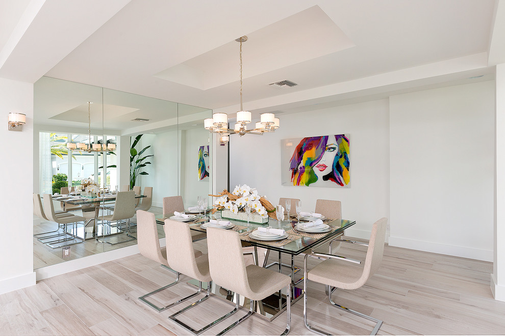 Modernes Esszimmer mit weißer Wandfarbe und hellem Holzboden in Miami