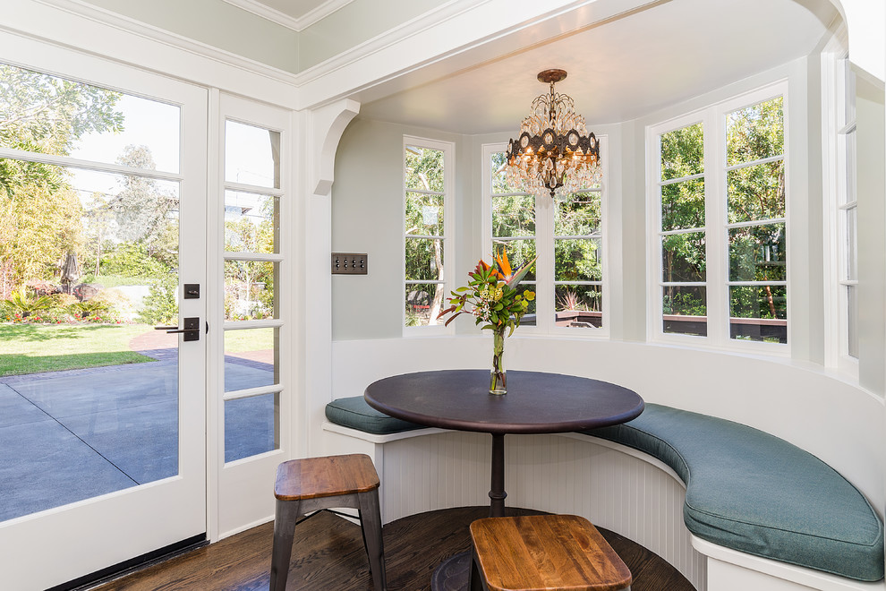 Immagine di una sala da pranzo aperta verso la cucina american style con pareti grigie, parquet scuro e pavimento marrone