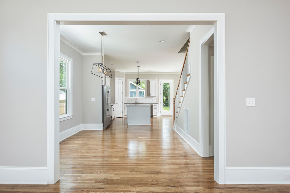 Rustikale Wohnküche mit beiger Wandfarbe, hellem Holzboden und braunem Boden in Charlotte