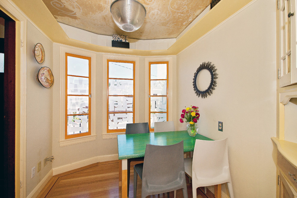 Foto de comedor actual pequeño cerrado con paredes blancas y suelo de madera en tonos medios