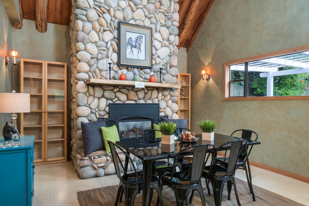 Inspiration for a rustic light wood floor dining room remodel in Seattle with multicolored walls, a standard fireplace and a stone fireplace