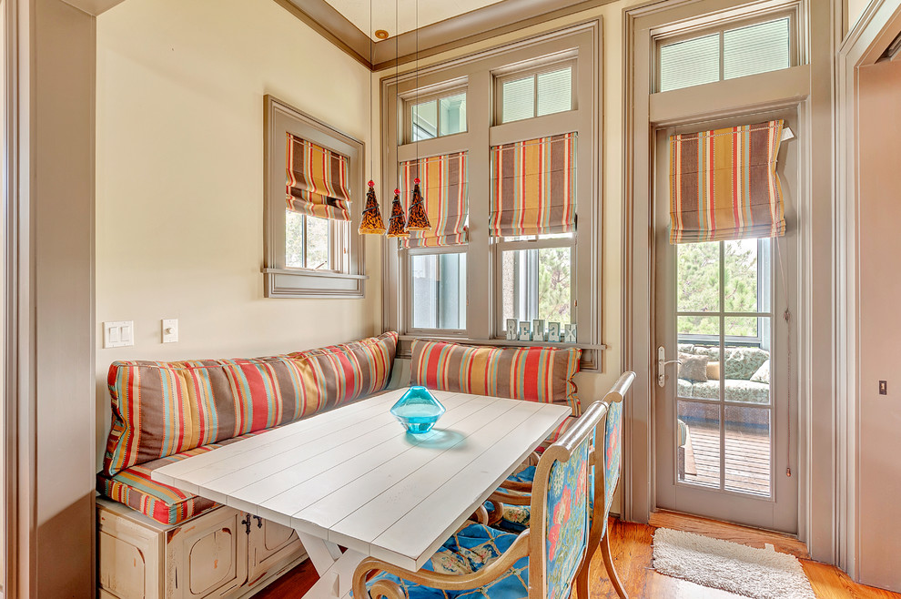 Diseño de comedor tropical con paredes beige y suelo de madera en tonos medios