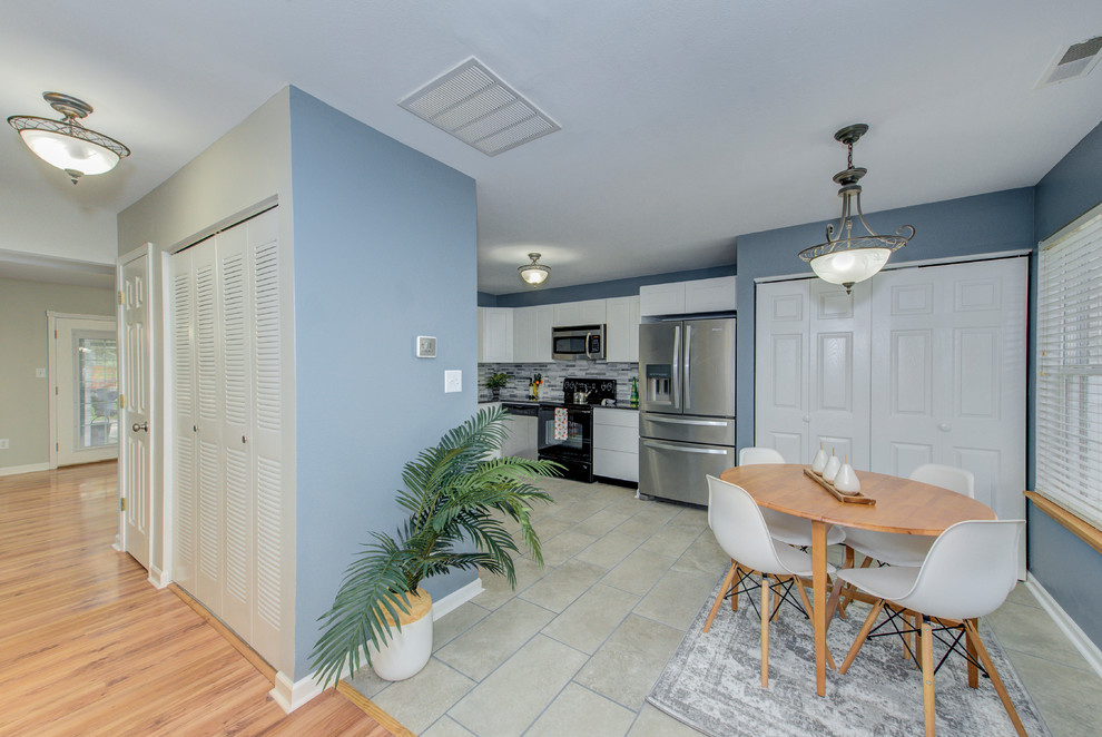 На фото: кухня-столовая среднего размера с синими стенами, полом из керамогранита и серым полом без камина