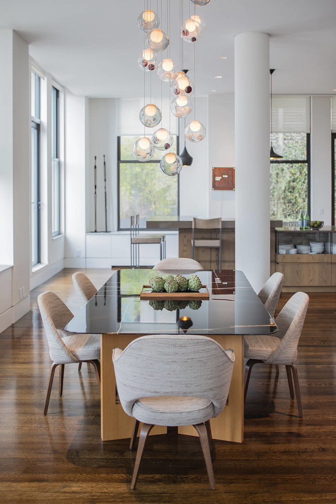 Idee per una grande sala da pranzo aperta verso il soggiorno design con pareti bianche, pavimento in legno massello medio e pavimento marrone