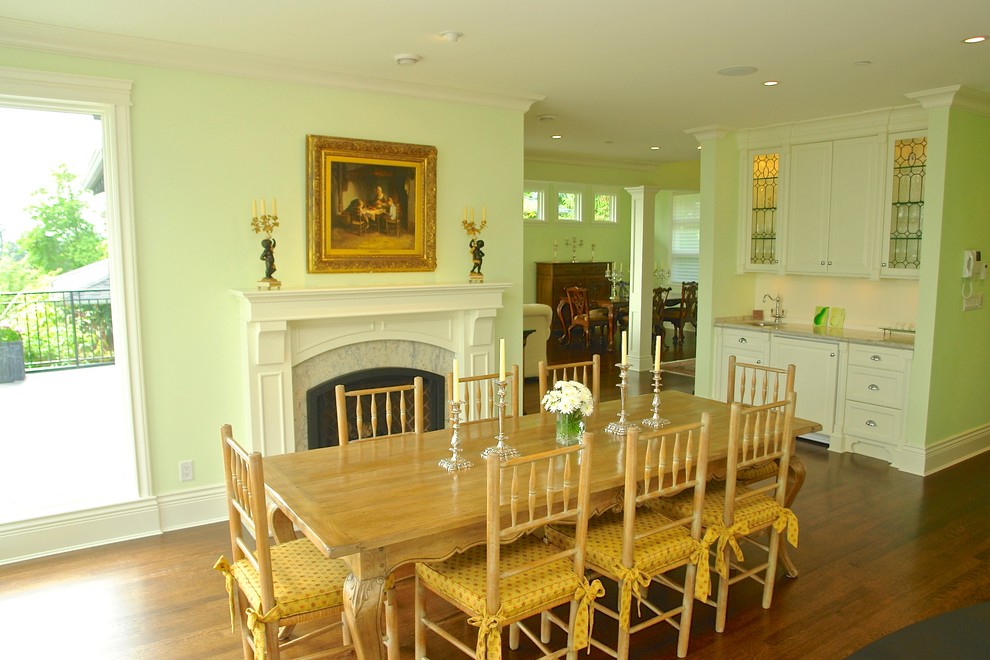 Пример оригинального дизайна: гостиная-столовая среднего размера в классическом стиле с зелеными стенами, темным паркетным полом, стандартным камином и фасадом камина из камня