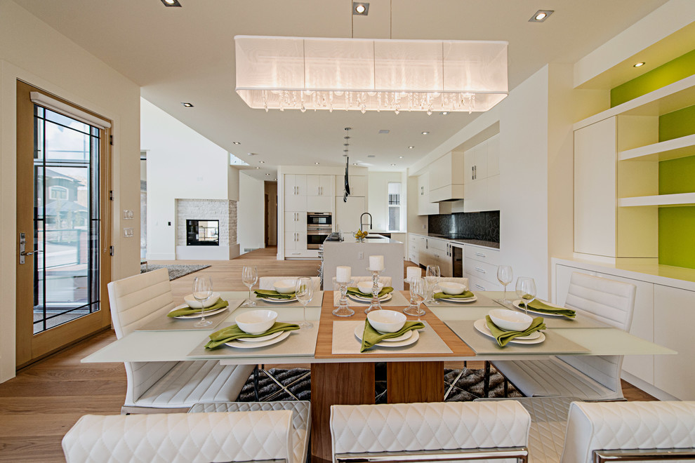 Inspiration pour une salle à manger ouverte sur le salon design avec un sol en bois brun, une cheminée double-face et un manteau de cheminée en pierre.