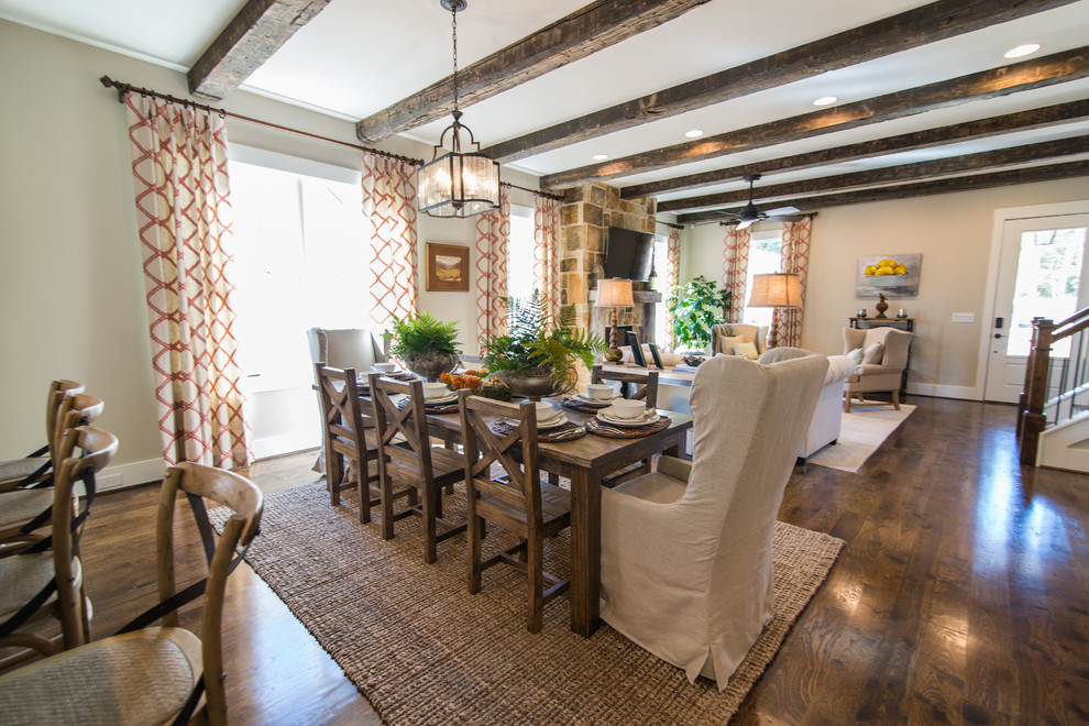 Immagine di una sala da pranzo aperta verso il soggiorno classica con pareti bianche, pavimento in legno massello medio, camino classico e cornice del camino in pietra
