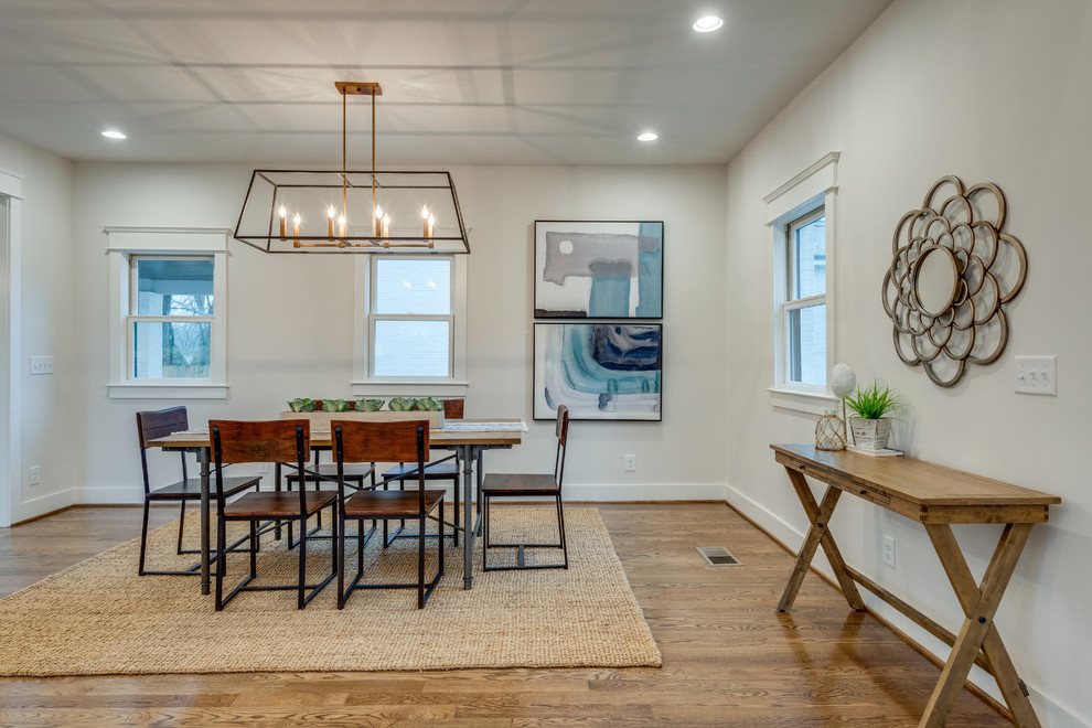 Ispirazione per una sala da pranzo aperta verso il soggiorno country di medie dimensioni con pareti bianche, pavimento in legno massello medio e pavimento marrone