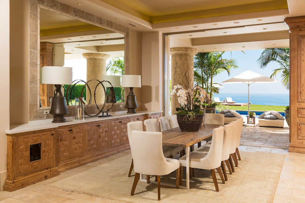 Photo of a large coastal dining room in Los Angeles with no fireplace and feature lighting.