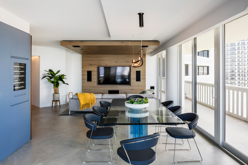 Immagine di una sala da pranzo aperta verso il soggiorno contemporanea con pareti bianche, pavimento in cemento e pavimento grigio