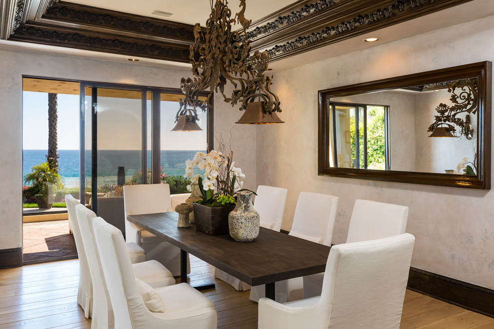 Aménagement d'une salle à manger méditerranéenne avec un mur beige et parquet clair.