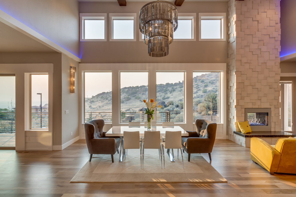 Aménagement d'une salle à manger ouverte sur le salon classique avec un mur beige, un sol en bois brun et une cheminée standard.