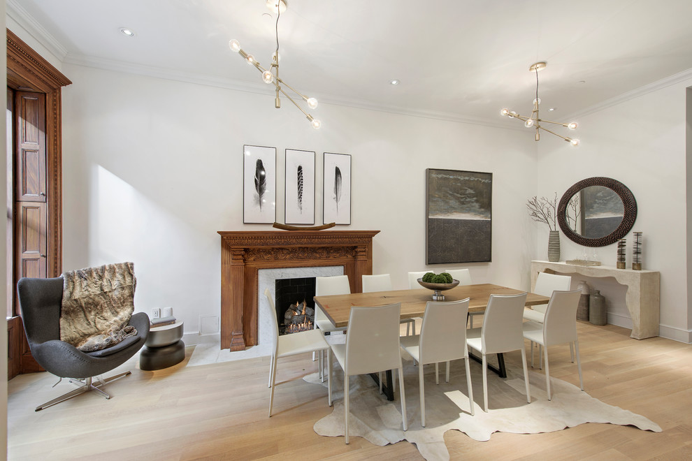 Idee per una sala da pranzo tradizionale con pareti bianche, parquet chiaro, camino classico e pavimento beige