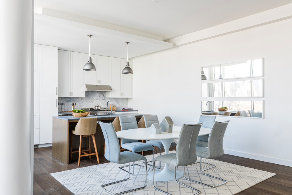 Ispirazione per una sala da pranzo aperta verso la cucina minimal con pareti bianche, parquet scuro e pavimento marrone