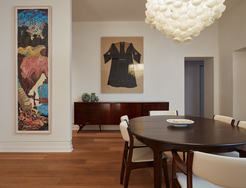 Exemple d'une salle à manger ouverte sur le salon tendance de taille moyenne avec un mur blanc, parquet clair, un sol marron et aucune cheminée.