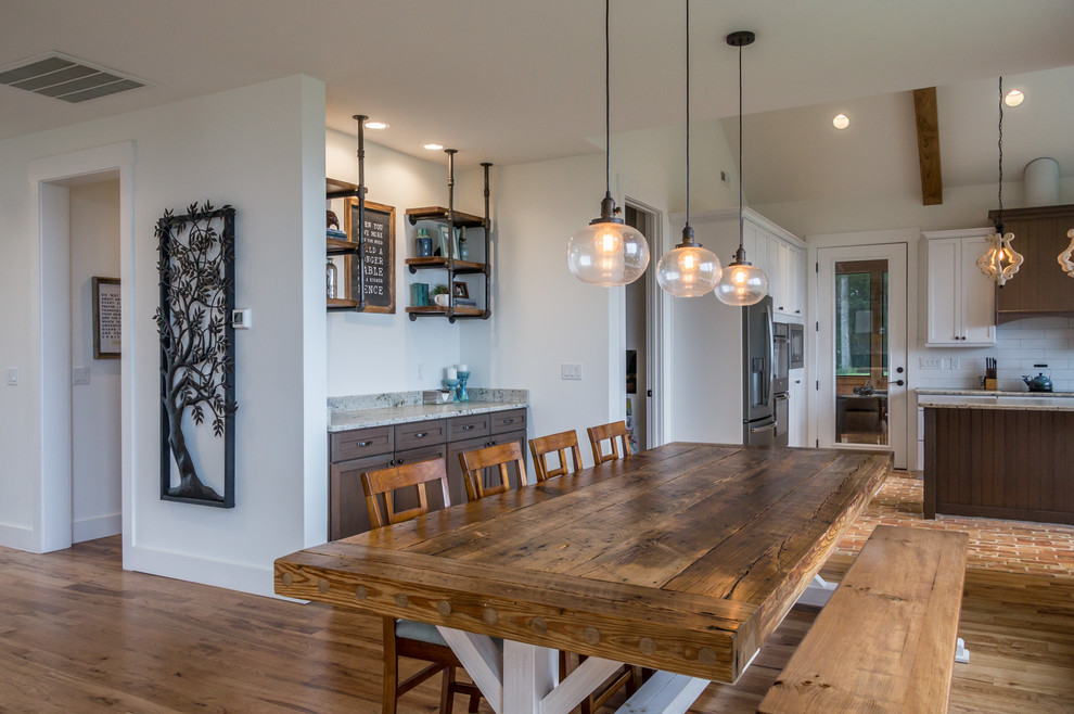 Esempio di una grande sala da pranzo aperta verso il soggiorno rustica con pareti bianche, pavimento in legno massello medio e pavimento marrone