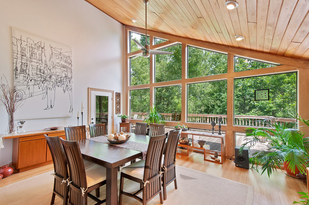 Aménagement d'une salle à manger classique avec un mur blanc et un sol en bois brun.