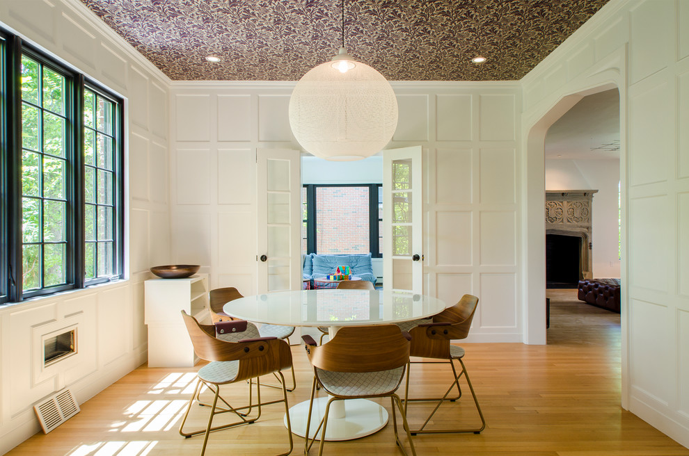 Diseño de comedor contemporáneo cerrado con paredes blancas y suelo de madera en tonos medios