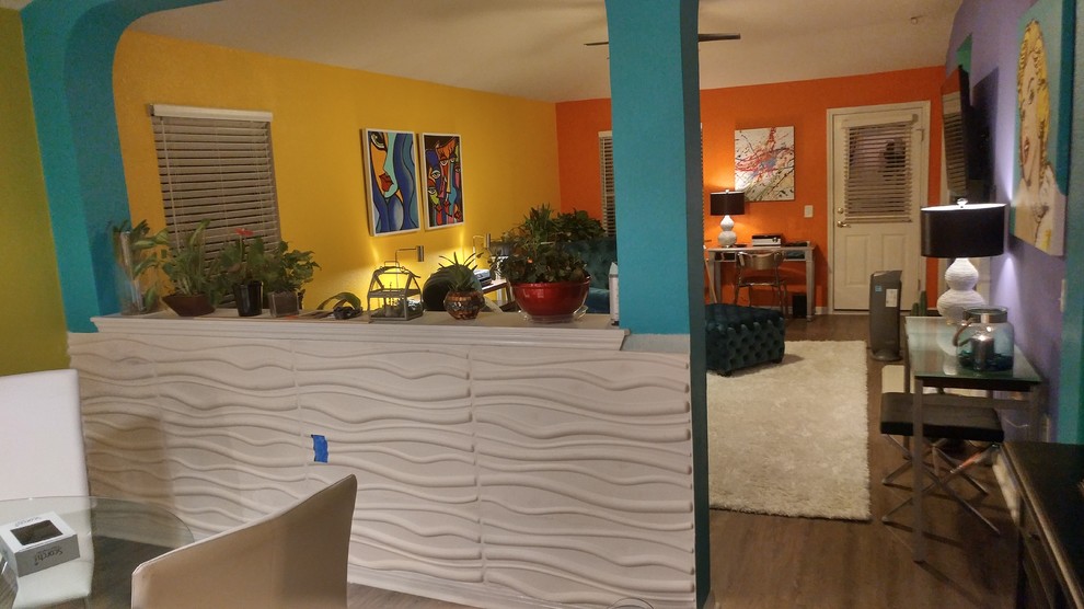 Foto di una sala da pranzo aperta verso la cucina minimalista di medie dimensioni con pareti blu e pavimento in laminato