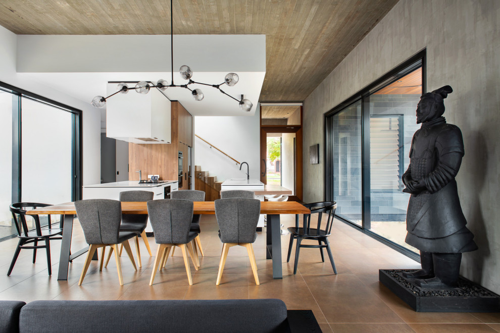 Immagine di una grande sala da pranzo aperta verso il soggiorno design con pareti grigie, pavimento in gres porcellanato, pavimento marrone e soffitto in legno