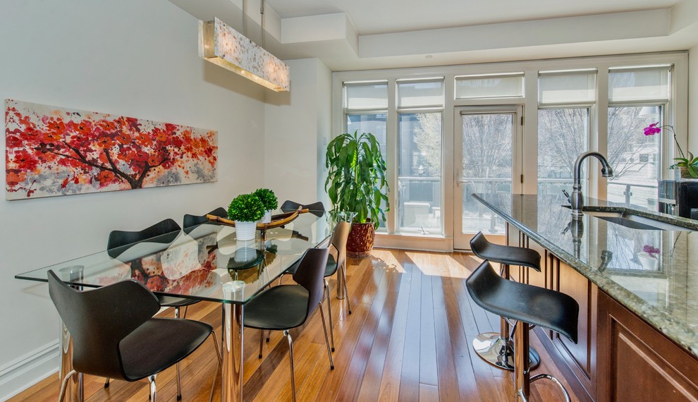 Immagine di una sala da pranzo aperta verso la cucina contemporanea di medie dimensioni con pareti bianche, pavimento in legno massello medio e pavimento marrone