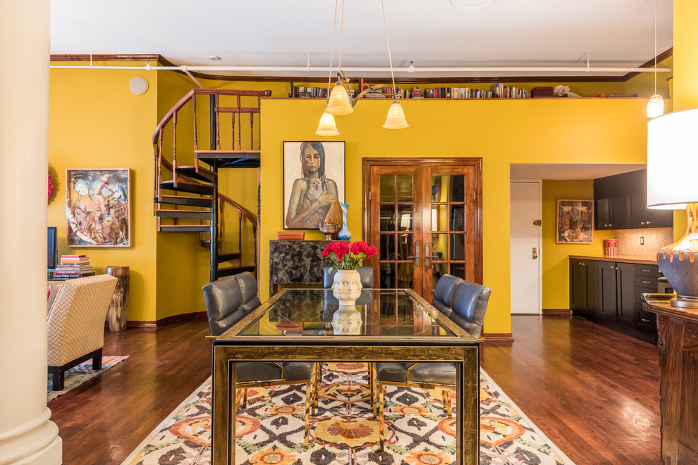 Пример оригинального дизайна: огромная гостиная-столовая в стиле фьюжн с желтыми стенами и темным паркетным полом без камина