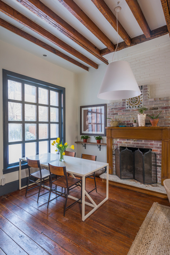 Inspiration for a large bohemian open plan dining room in Philadelphia with a brick fireplace surround, white walls, dark hardwood flooring, a standard fireplace and brown floors.
