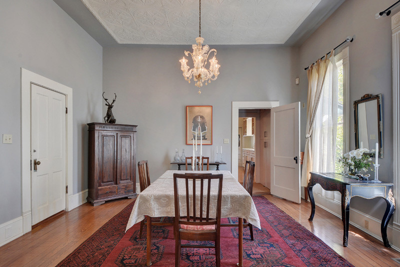 Пример оригинального дизайна: гостиная-столовая в викторианском стиле с серыми стенами и паркетным полом среднего тона без камина