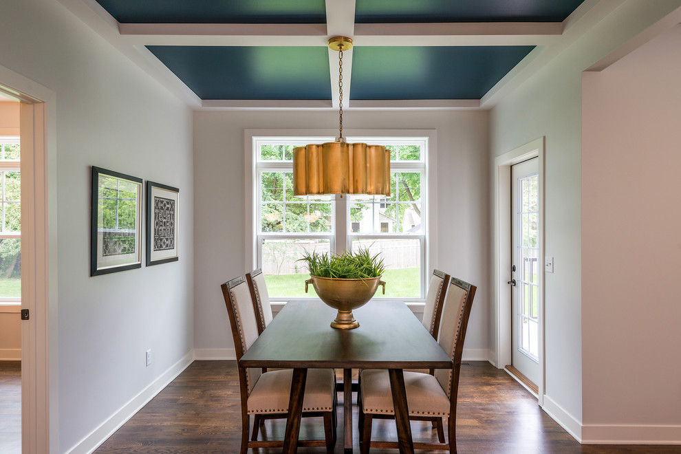 Exemple d'une salle à manger chic fermée avec un mur blanc, parquet foncé et un sol marron.