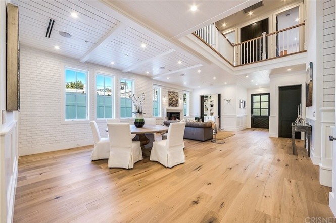 Geräumiges Landhausstil Esszimmer mit weißer Wandfarbe, hellem Holzboden, Kamin, Kaminumrandung aus Stein und braunem Boden in Los Angeles