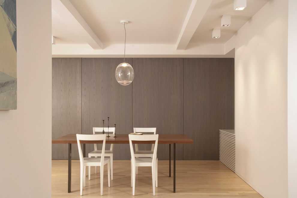 Immagine di una sala da pranzo design con pareti beige e pavimento in legno massello medio