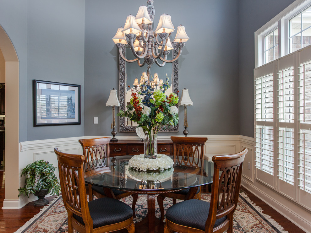 Classic enclosed dining room in Other with blue walls, dark hardwood flooring and feature lighting.