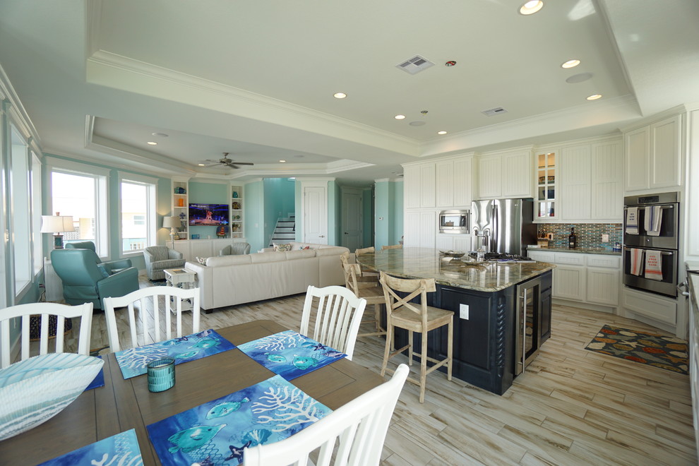 Esempio di una sala da pranzo aperta verso il soggiorno costiera di medie dimensioni con pareti blu, pavimento in gres porcellanato e nessun camino