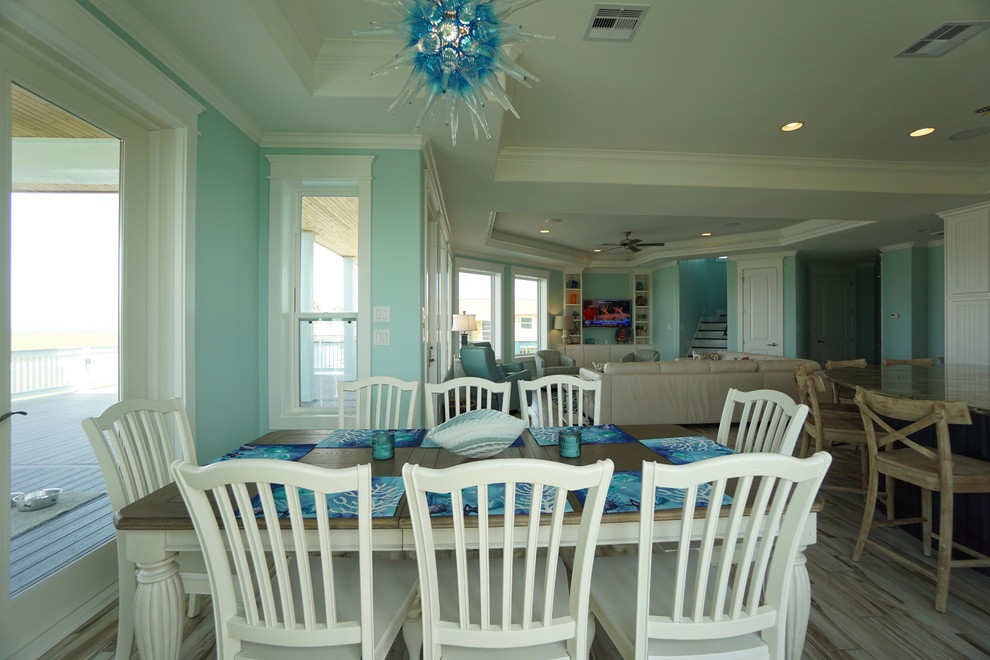 Esempio di una sala da pranzo aperta verso il soggiorno stile marino di medie dimensioni con pareti blu, pavimento in gres porcellanato e nessun camino