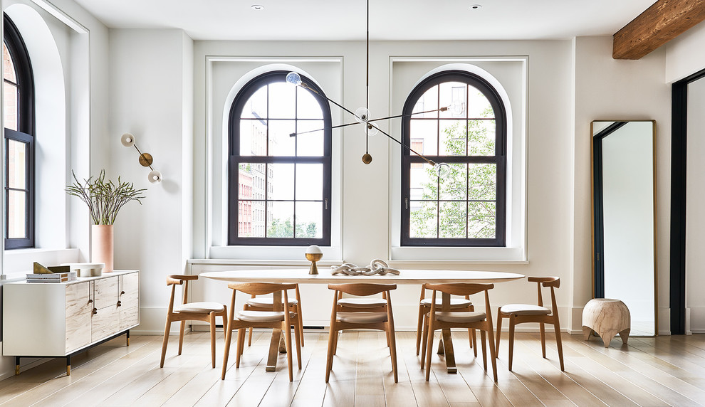 Cette photo montre une salle à manger ouverte sur le salon scandinave avec un mur blanc, parquet clair, aucune cheminée et un sol beige.