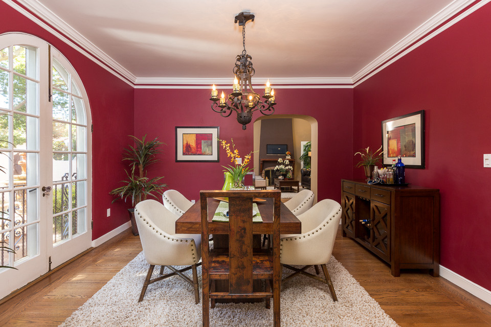 Exemple d'une salle à manger chic de taille moyenne avec un mur rouge, parquet clair, aucune cheminée et un sol beige.