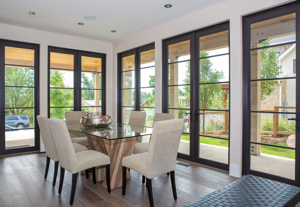 Immagine di una sala da pranzo minimalista di medie dimensioni con pareti beige, pavimento in legno massello medio e pavimento marrone