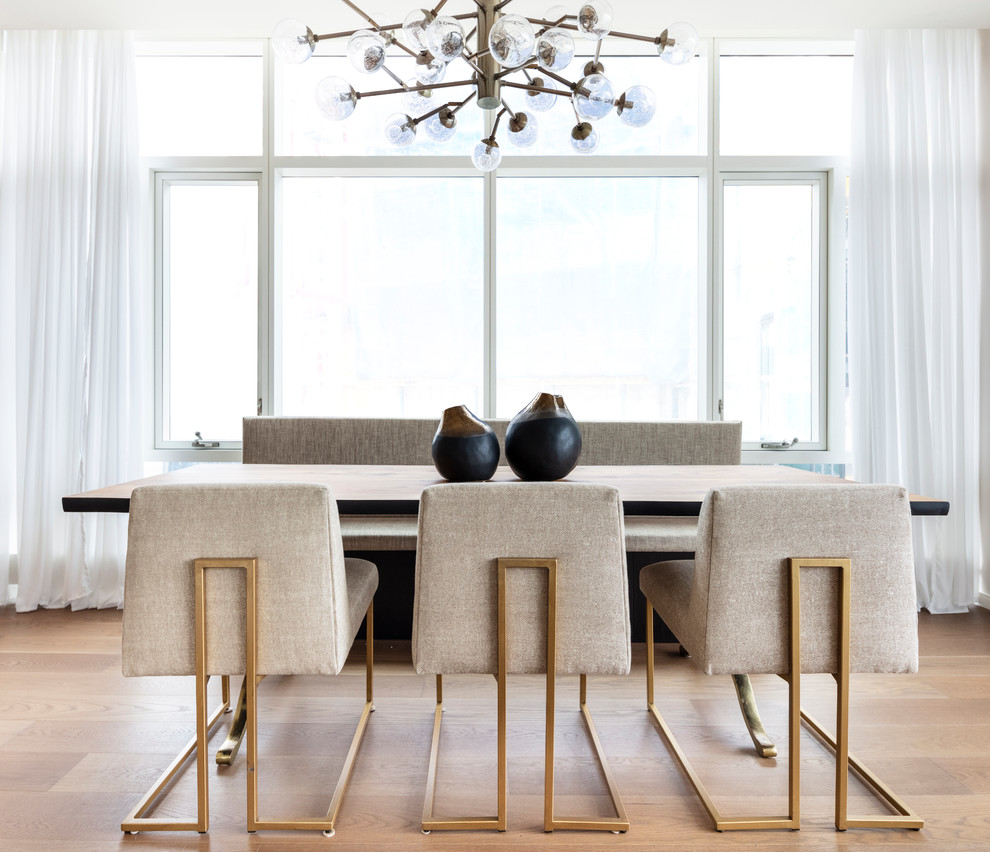 Immagine di una sala da pranzo contemporanea con parquet chiaro, nessun camino e pavimento beige