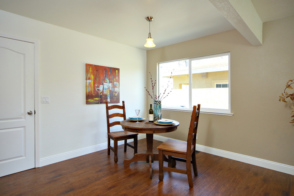 Idée de décoration pour une petite salle à manger ouverte sur la cuisine design avec un mur multicolore, un sol en bois brun, une cheminée standard et un manteau de cheminée en brique.
