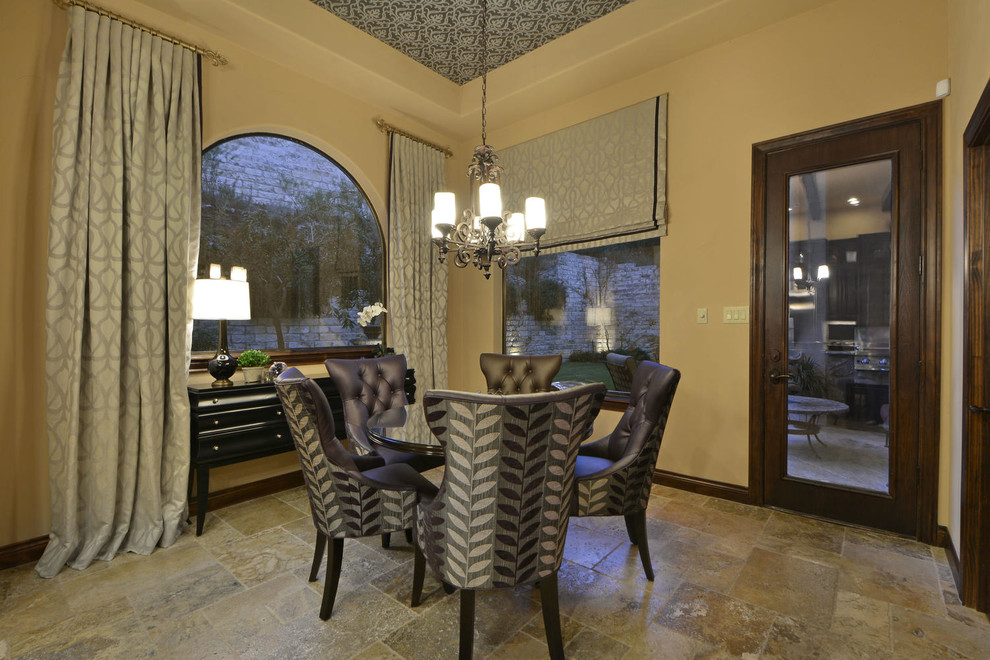 Inspiration for a mediterranean enclosed dining room in Austin with beige walls and travertine flooring.