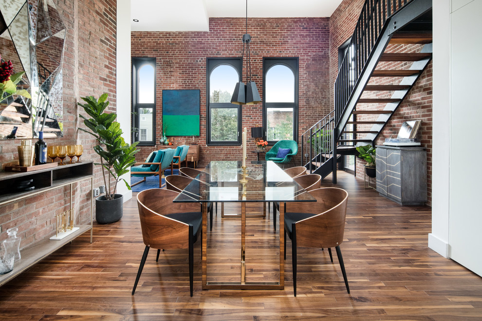 Design ideas for a large industrial open plan dining room in New York with dark hardwood flooring, a brick fireplace surround and feature lighting.