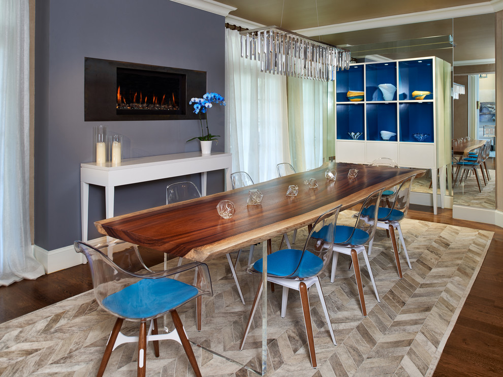 Réalisation d'une salle à manger design avec un mur bleu, parquet foncé et une cheminée standard.