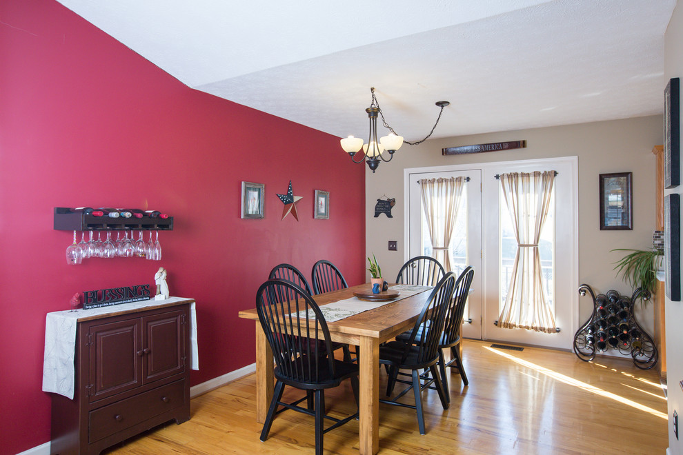 Ispirazione per una grande sala da pranzo aperta verso la cucina tradizionale con pareti rosse e parquet chiaro