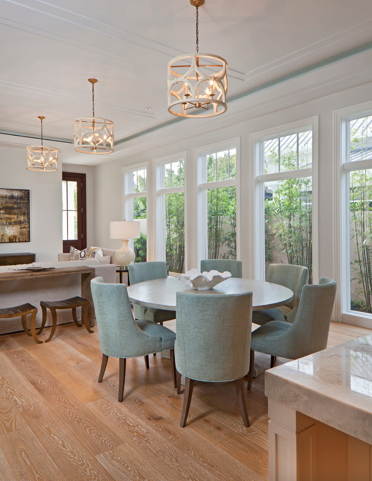 Réalisation d'une salle à manger ouverte sur le salon tradition de taille moyenne avec un mur blanc et un sol en bois brun.