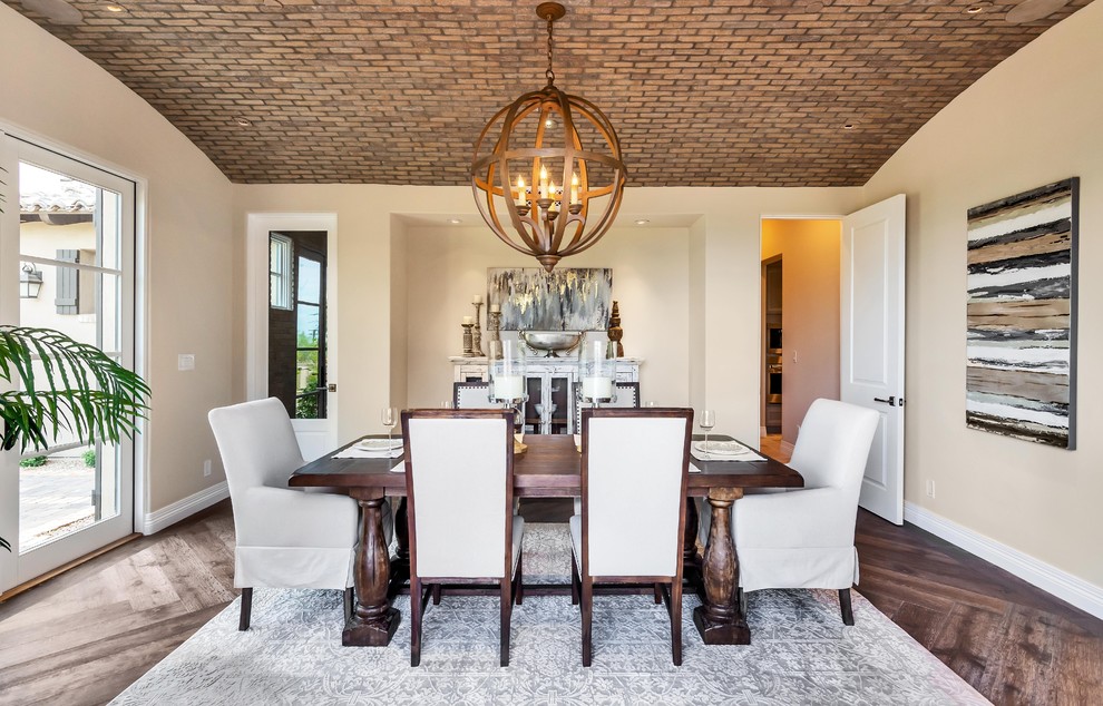 This is an example of a mediterranean enclosed dining room in Phoenix with beige walls, dark hardwood flooring and brown floors.